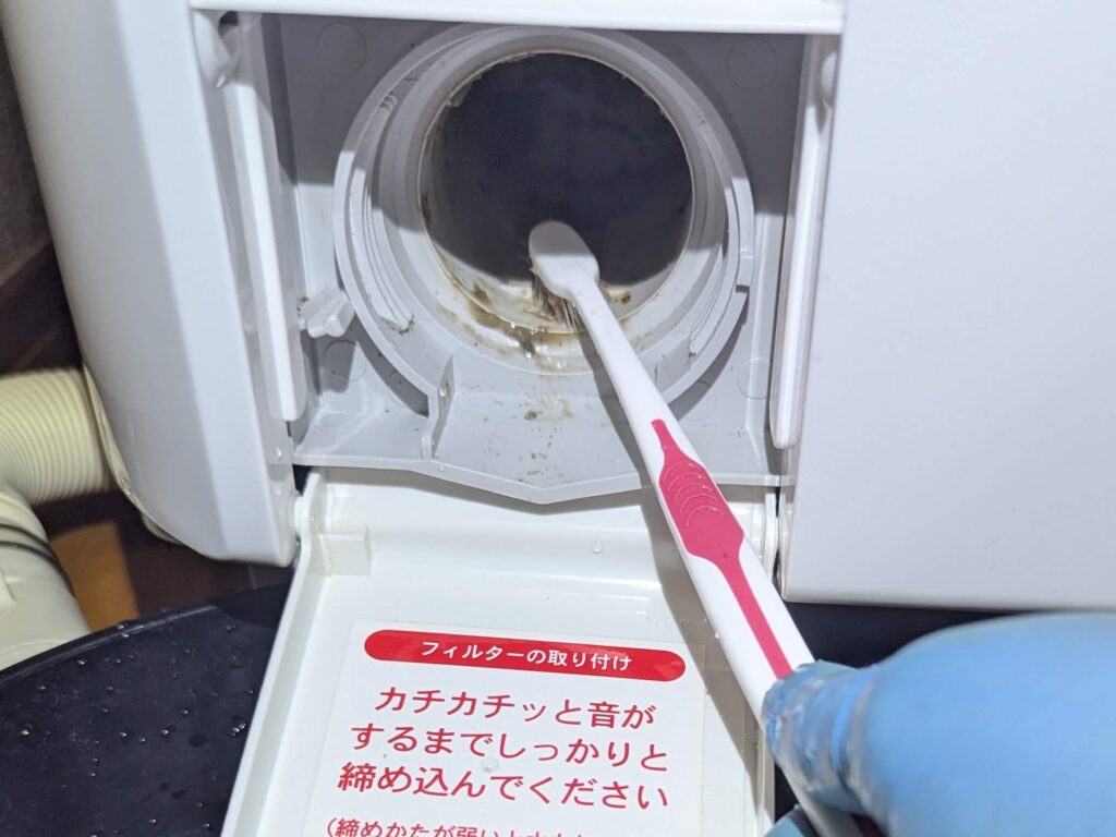 洗濯機側を歯ブラシで掃除する