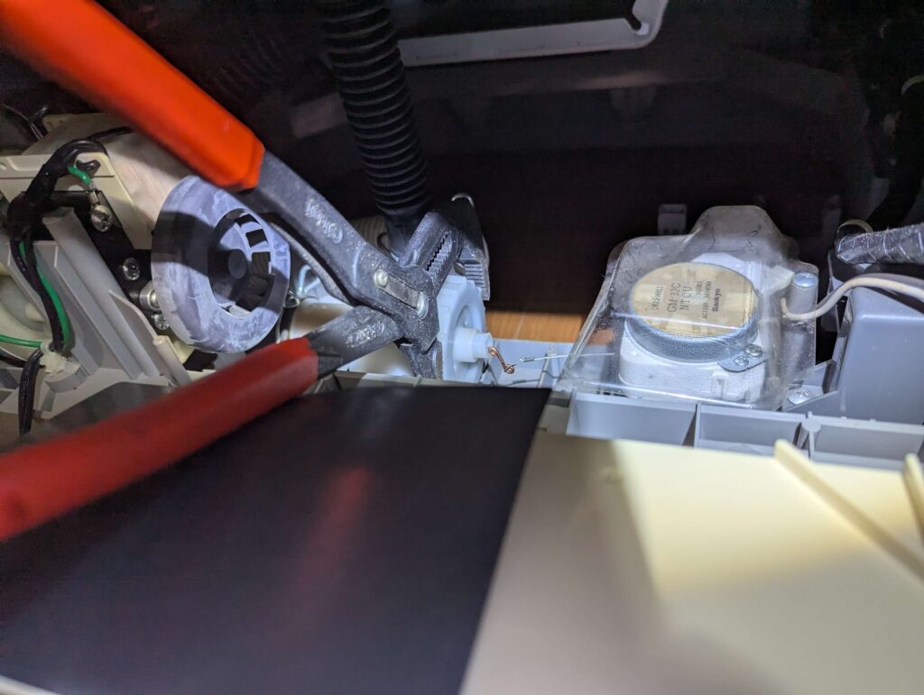 排水弁キャップをウォーターポンププライヤーで反時計回りに回して取り外す