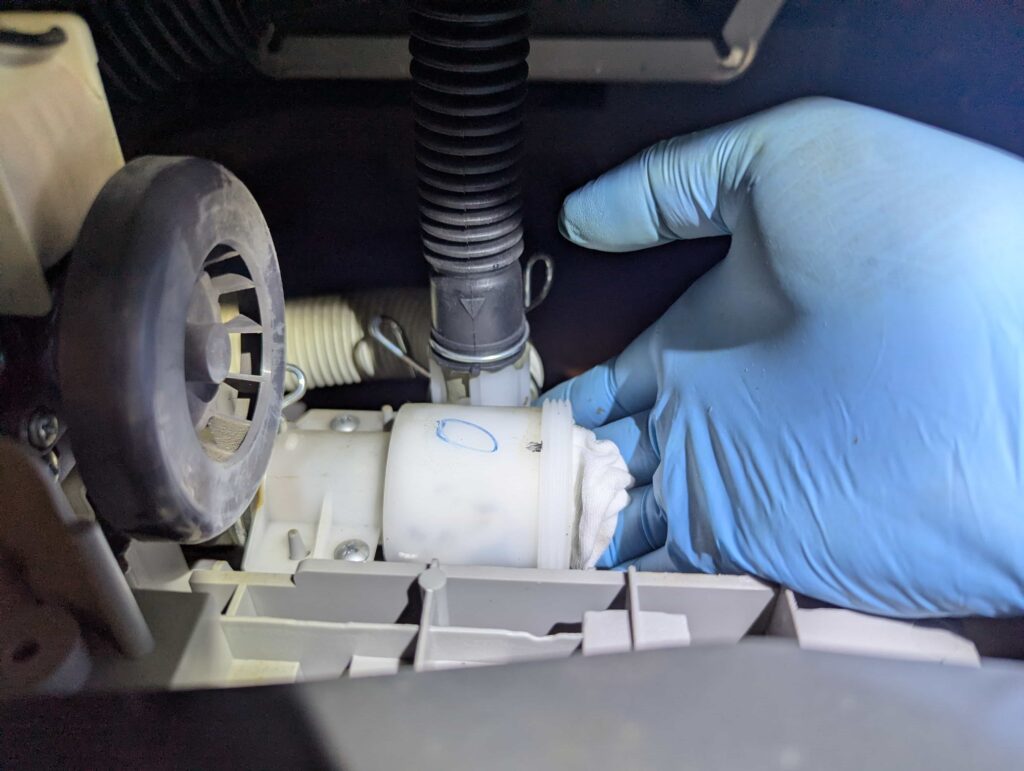 排水弁ケース内部をウエス（布）で拭いて清掃する様子