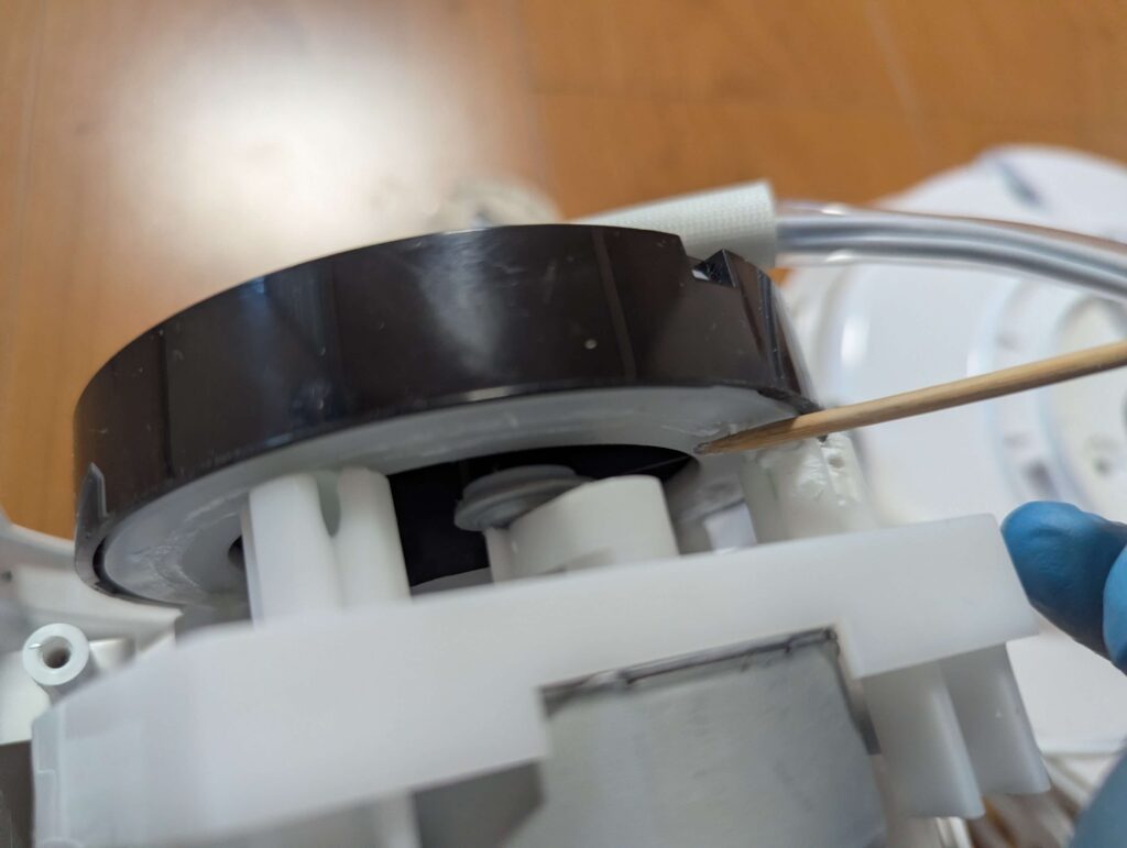 タワーファンの首振り機構にシリコングリスを塗布している様子