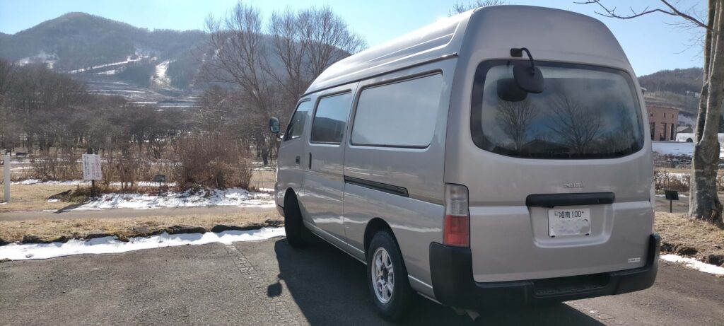 野辺山天文台の駐車場に停車しているいすゞコモ（E25キャラバン）。車中泊の旅の風景