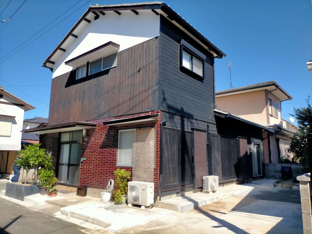 減築後の実家外観（黒い焼杉板と白いモルタルのモダンなコントラスト