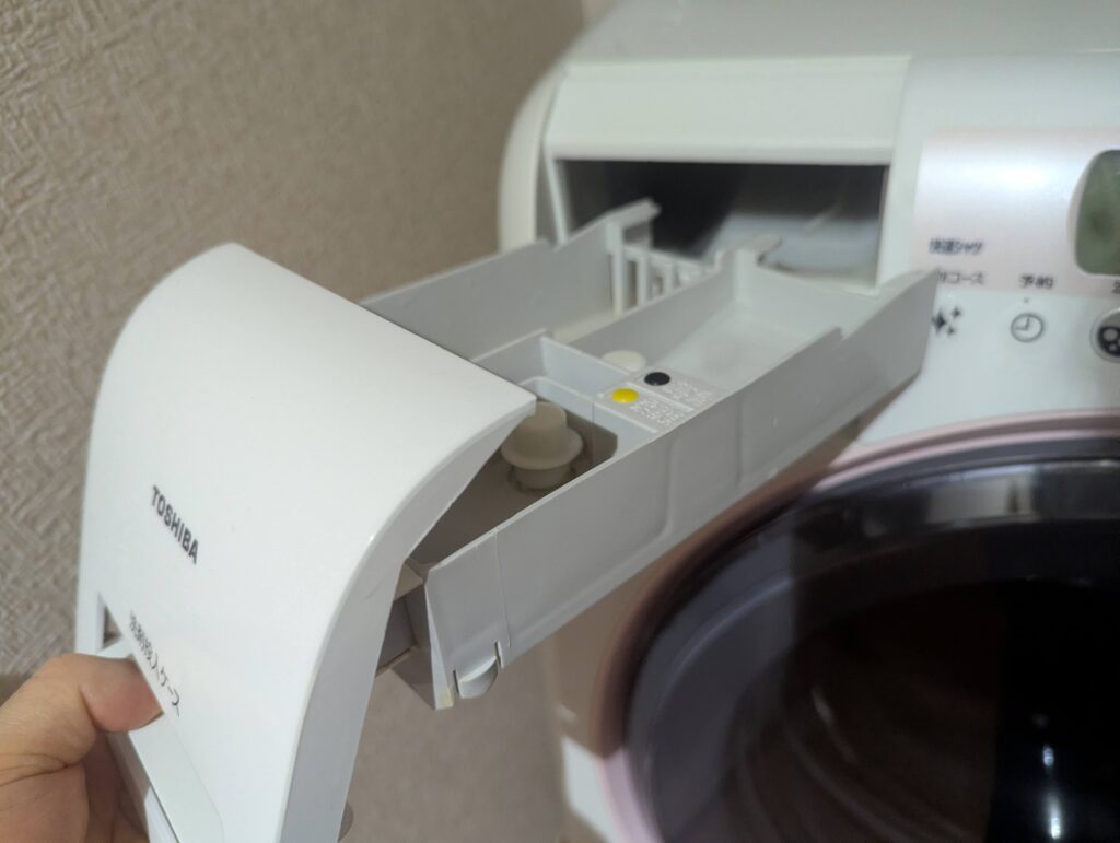 ドラム式洗濯機の洗剤投入ケース内の汚れ・詰まり。溶け残った洗剤・柔軟剤が蓄積してカビの温床になる。黒いワカメ基本診断Step2の確認箇所。異物除去・清掃後に槽洗浄コースを実施することで解決できる場合がある