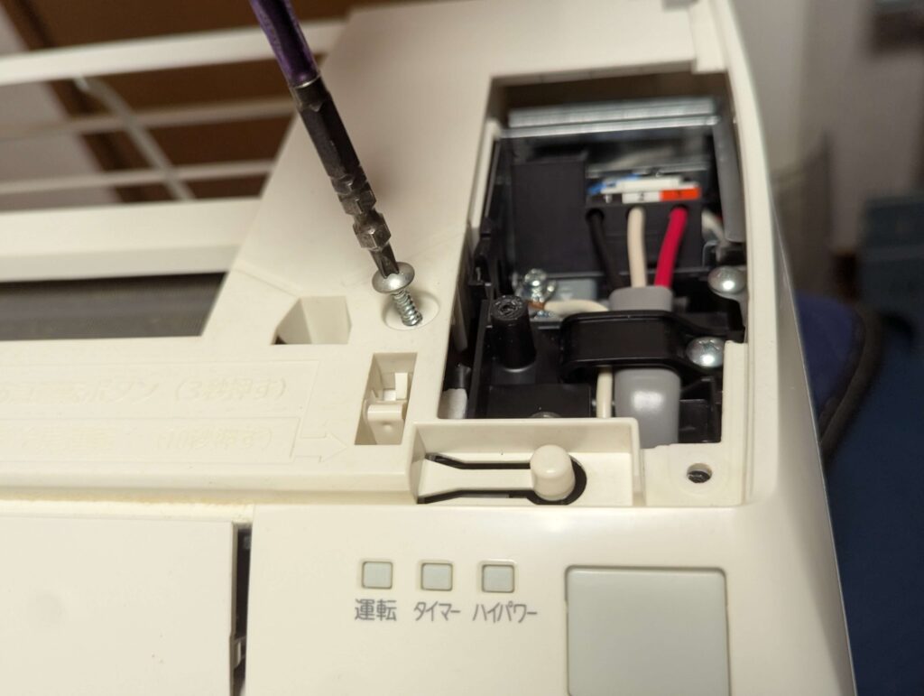 フロントカバーの固定ネジを外している作業