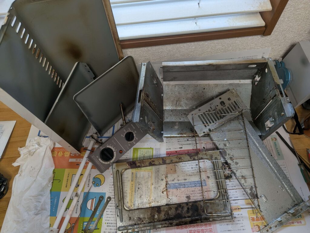 完全に分解されたオーブントースター日立 TO-BT9 のパーツ群