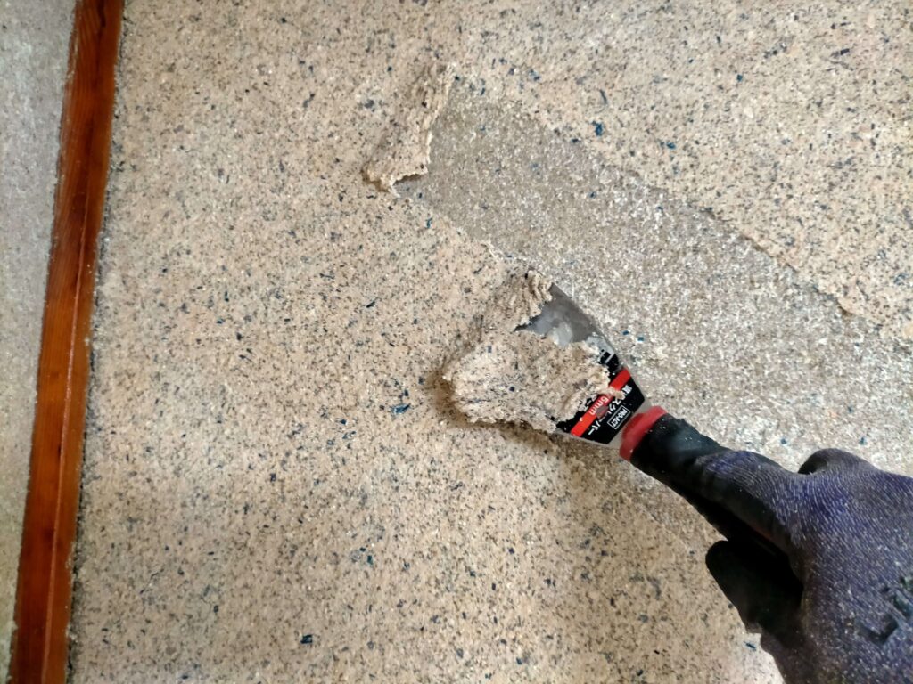 実家の内装リノベーションで、湿らせた古い繊維壁を効率よく剥がす作業に使う皮スキ