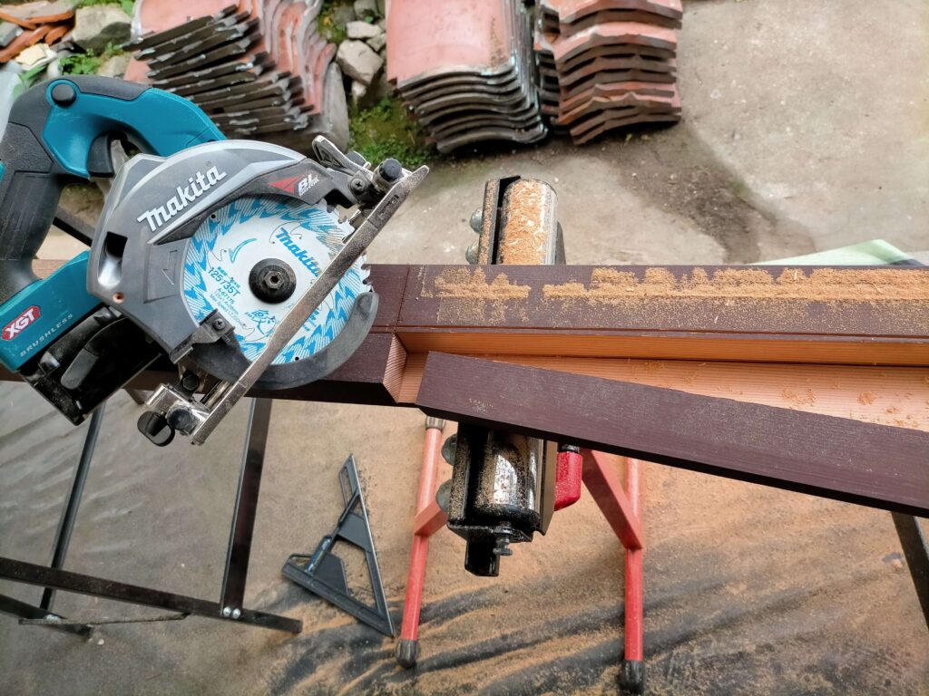 マキタの40Vmax充電式丸鋸を使用して、実家のリフォームで出た古い硬い柱材を、ガイドなしのフリーハンドで真っ直ぐ縦挽き（リップカット）している様子