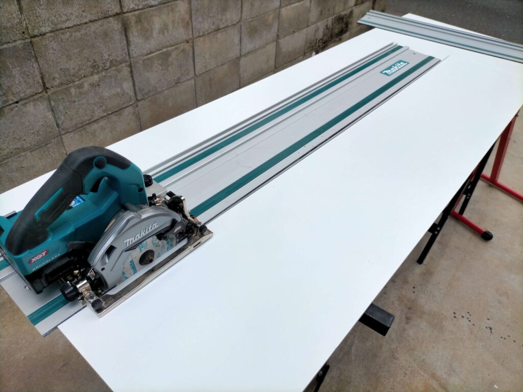 マキタの長尺定規と丸ノコ用ガイドレールアダプタを使用して、滑りにくいケイカル板を真っ直ぐスムーズに切断しているDIY作業風景