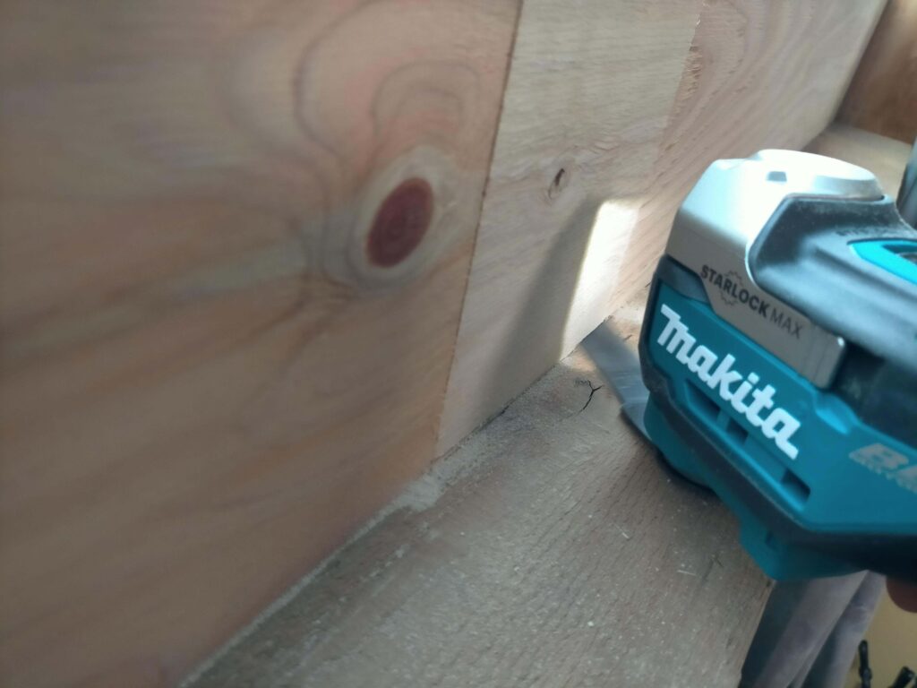 マキタのマルチツールを使って、構造用合板を窓枠の形状に合わせてキワ切りしている実家リフォームの様子