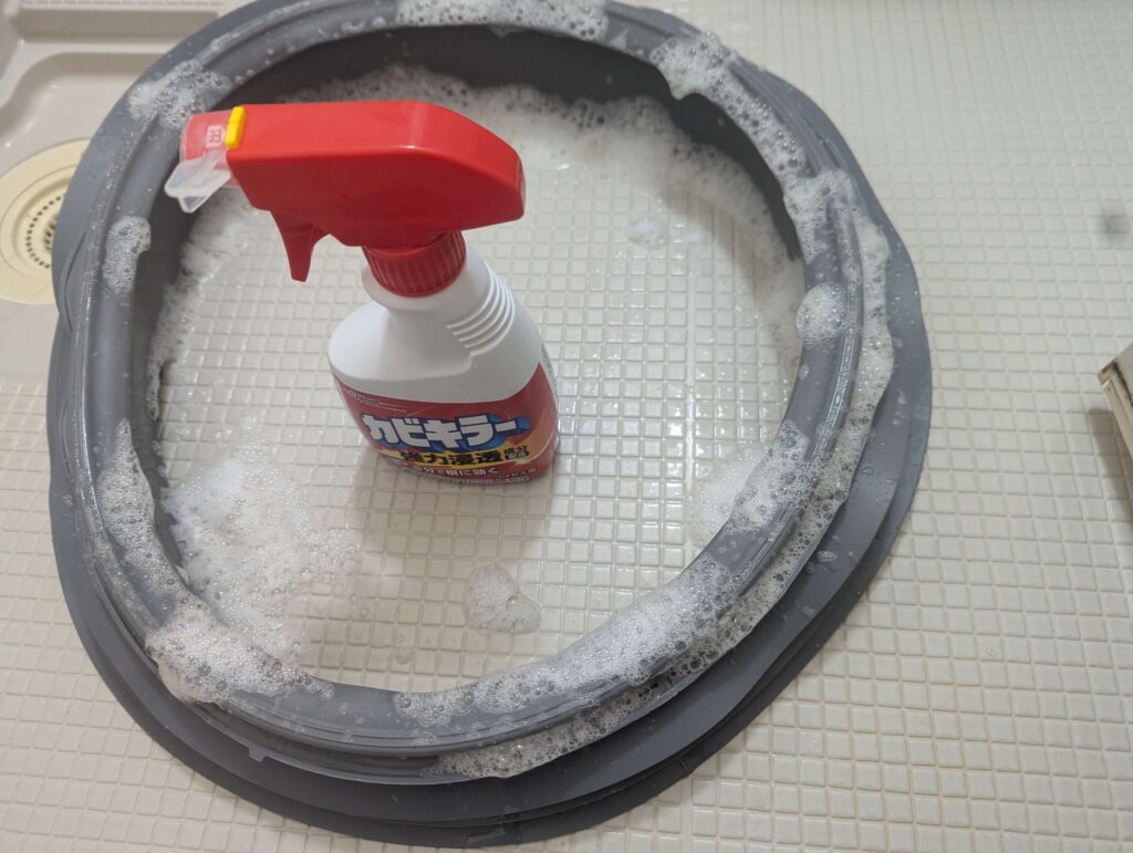 東芝 TW-160SCH ドラム式洗濯機のドアパッキン(ゴムシール)にカビキラー(塩素系カビ取り剤)を数回噴霧してカビを撃退している状態。漬け置き後の仕上げカビ取り処理。19年使用でもパッキン本体はまだ現役として継続使用可能と判断
