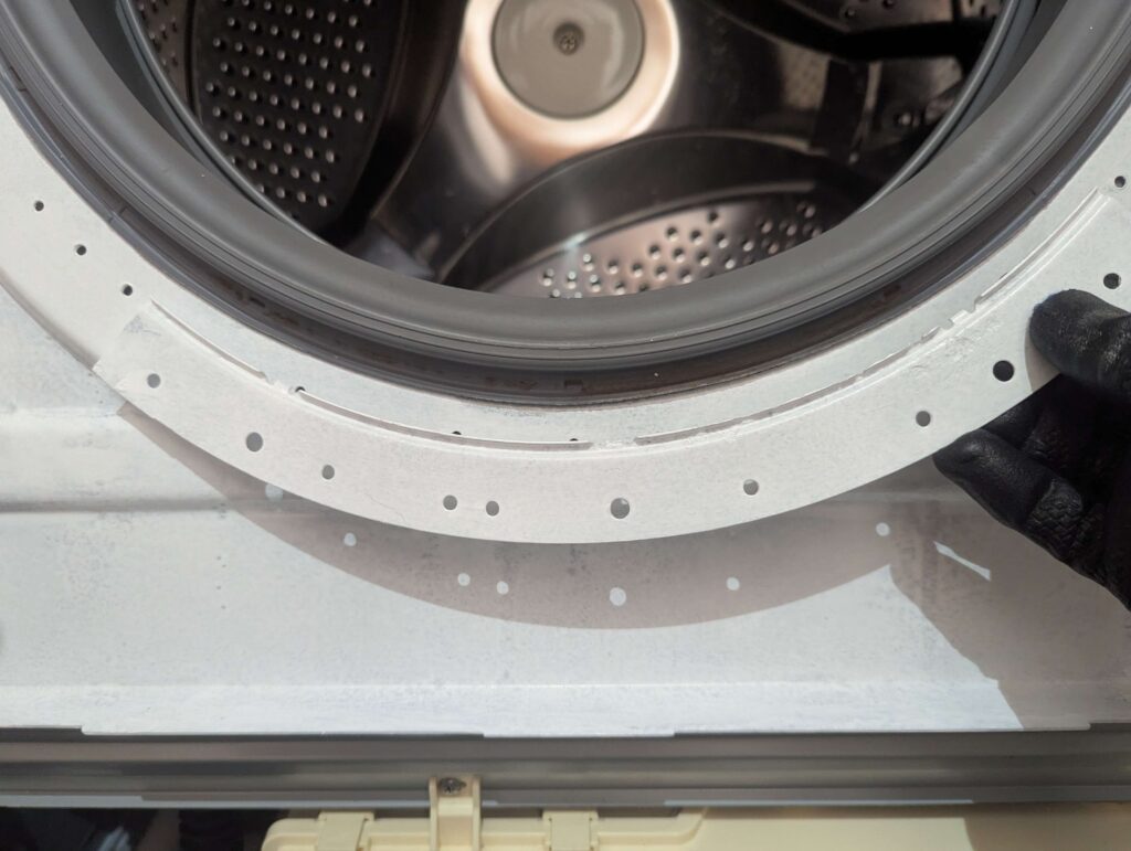 東芝 TW-160SCH ドラム式洗濯機のドアパッキン押えプレート4枚を固定ネジで再取り付けした状態。サビ取り・サビキラープロ防錆処理済みの押えプレートを装着。次に前面カバー(大)と磁気センサーを取り付ける