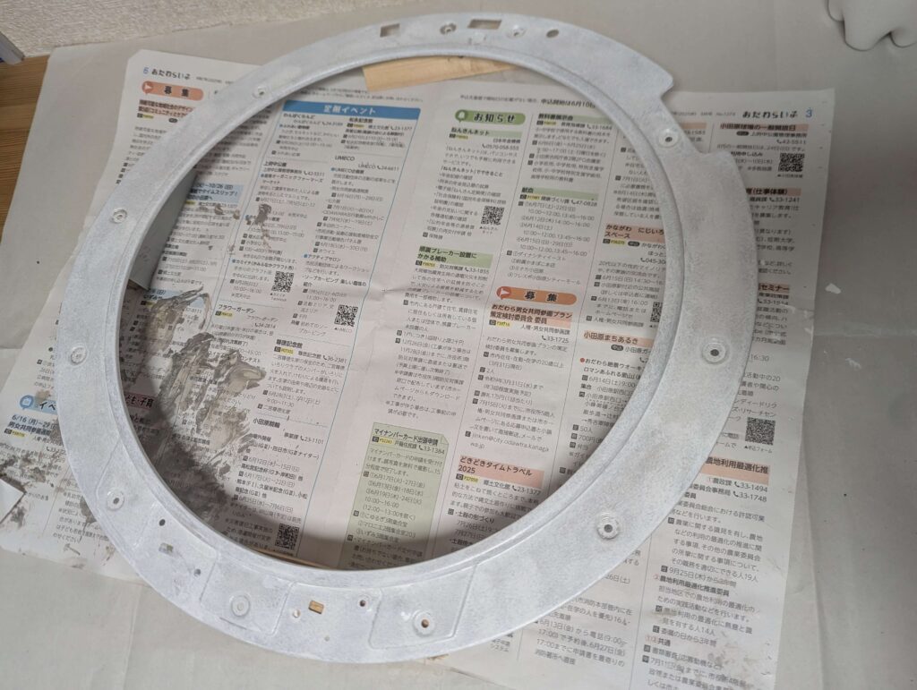 東芝 TW-160SCH ドラム式洗濯機のドア内パネルにサビキラー上塗りをローラー刷毛で施工している状態。防錆処理の最終仕上げ工程。ドア内側の腐食箇所全体に均一に塗布