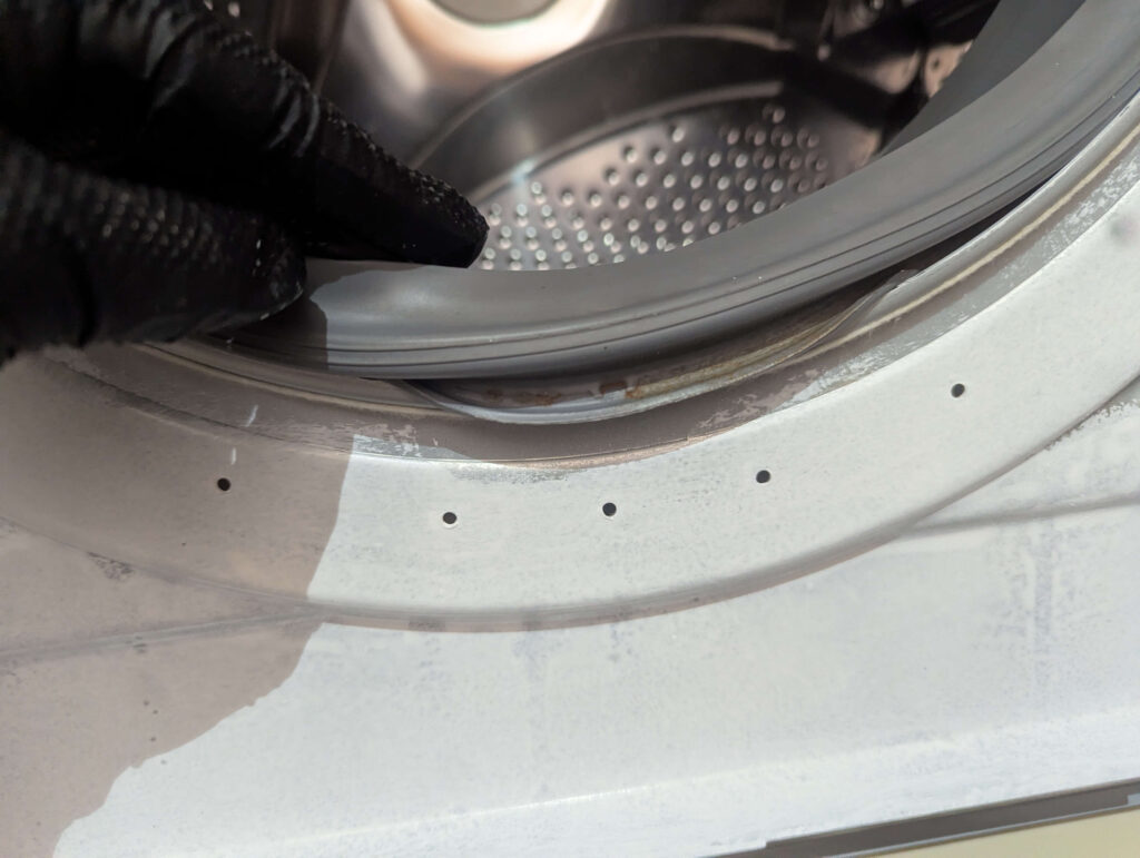 東芝 TW-160SCH ドラム式洗濯機の前面板金パネルにドアパッキンの前側をはめ込んでいる状態。板金パネルとドアパッキンの密着部分の再組み付け手順