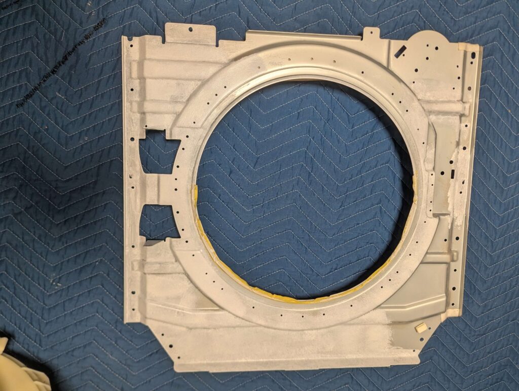 東芝 TW-160SCH ドラム式洗濯機の前面パネルにサビキラー塗布後にローラー刷毛で上塗りしている状態。仕上げ塗装で防錆効果と外観を向上させる工程