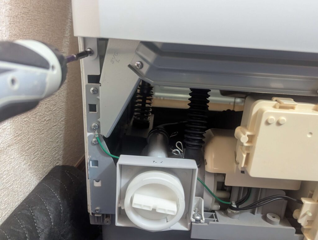 東芝 TW-160SCH ドラム式洗濯機の前面下部カバー(キックプレート)を外した後に見える前面カバー(大)の固定ネジ位置。キックプレート取り外し後に初めてアクセスできる下部隠しネジ