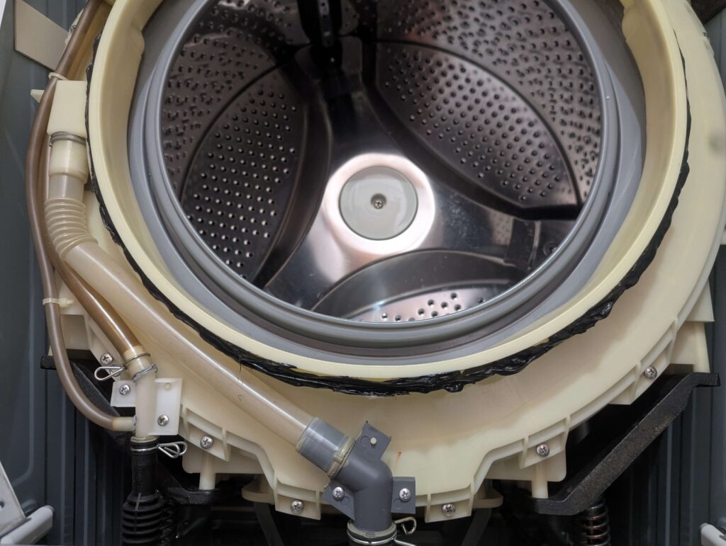 東芝 TW-160SCH ドラム式洗濯機の外槽前カバーの時計の2時〜10時の位置(上部弧)にシリコンシーラントを均一に塗布した状態。元々塗られていた水漏れ防止処置の再現。この範囲への塗布後に合いマークを合わせてドアパッキンをはめ込む