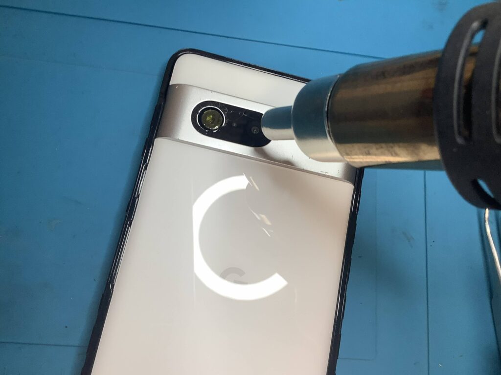 ヒートガンで熱を加えてPixel 7の割れたカメラガラスの接着剤を溶かす様子