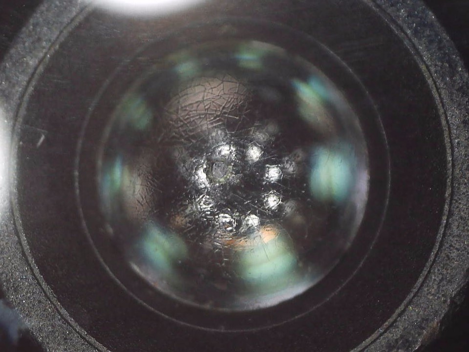 300℃のヒートガンで熱ダメージを受け、ARコーティングがひび割れた広角レンズの顕微鏡画像