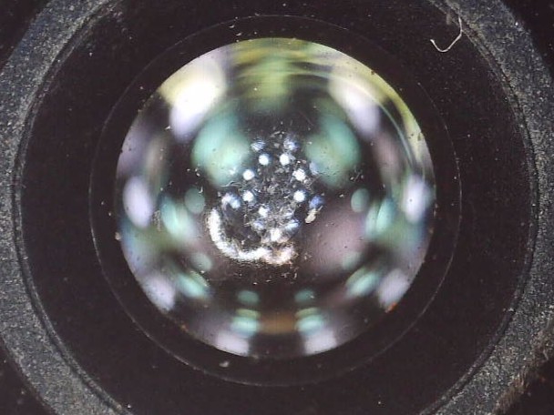 修理作業前のPixel 7広角レンズ表面の顕微鏡画像（ARコーティングに傷あり）