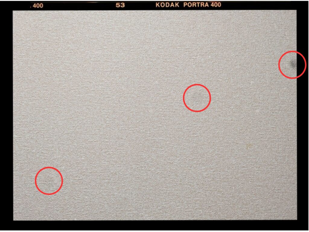 Pixel 7のカメラ（1倍）で白い壁を撮影し、センサー上に明確な「黒い点」ゴミと「透明の点」を3つ確認した画像