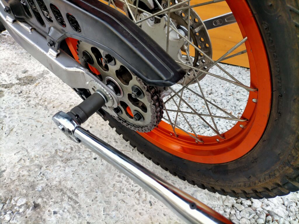 セロー250のチェーン取り外し手順：リヤホイールを浮かせアクスルナットを緩める