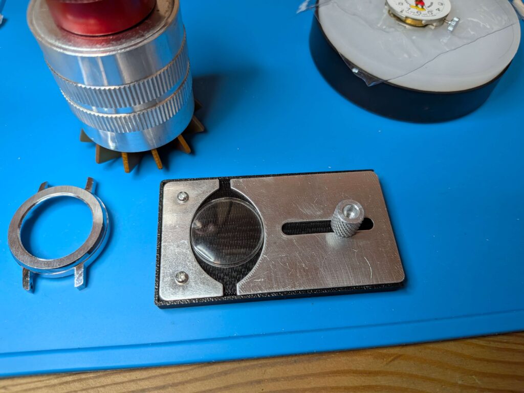 凸型プラスチック風防の圧入①風防挿入治具の爪が奥まで入らないように付属の治具に風防を固定する