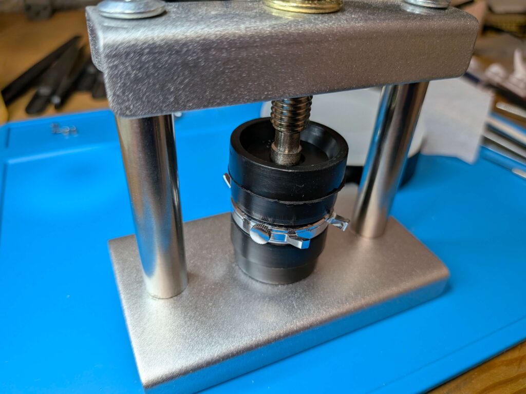 時計用裏蓋閉じ器（ケースプレス）を使ってブラッドリー社製首振りミッキーマウス腕時計の裏蓋を閉じる様子