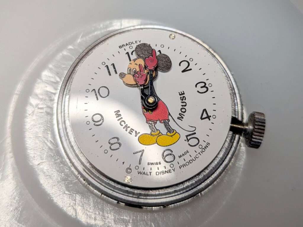 12時付近でミッキーマウスの頭と短針が接触して針が止まっているブラッドリー社製腕時計のトラブル状態
