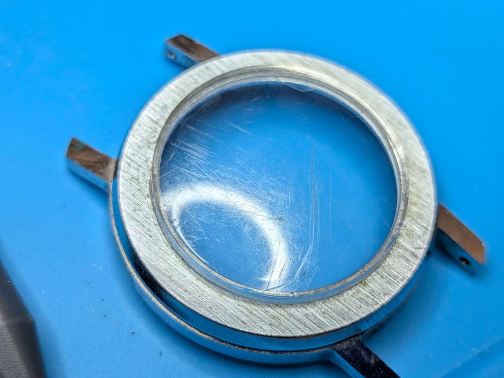 ブラッドリー社製首振りミッキーマウス腕時計の風防（プラスチック風防）についた傷の修復前の状態