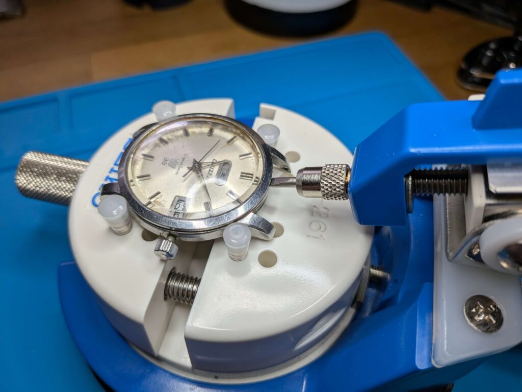 高級こじ開け工具SEIKO S-261を使用してシチズン・クリスタルセブン33石のベゼルを外している様子