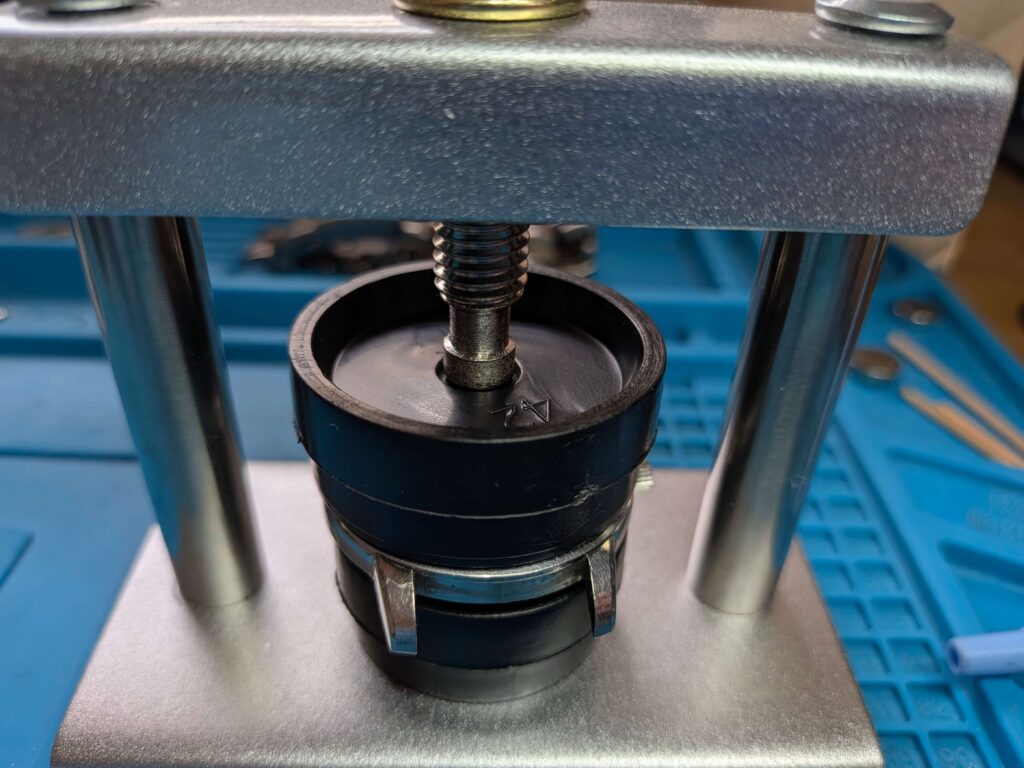 時計用裏蓋閉じ器(風防挿入器)を使用してベゼルと風防をケースに圧入しているシチズン・クリスタルセブン33石