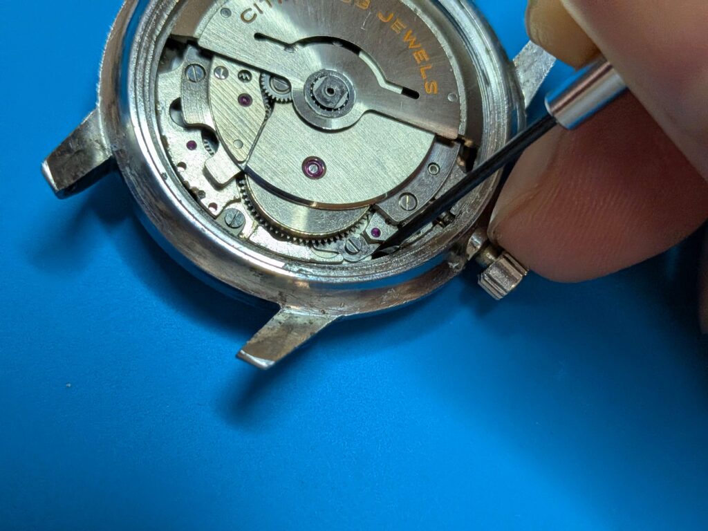 時計用マイナスドライバーを使用してシチズン・クリスタルセブン33石のこはぜを解放しゼンマイの動力を抜く様子