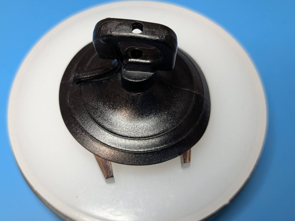 ワンピースケースの分解工程で風防(ガラス)を吸盤工具で正面から引き抜いて外しているシチズン・クリスタルセブン27石