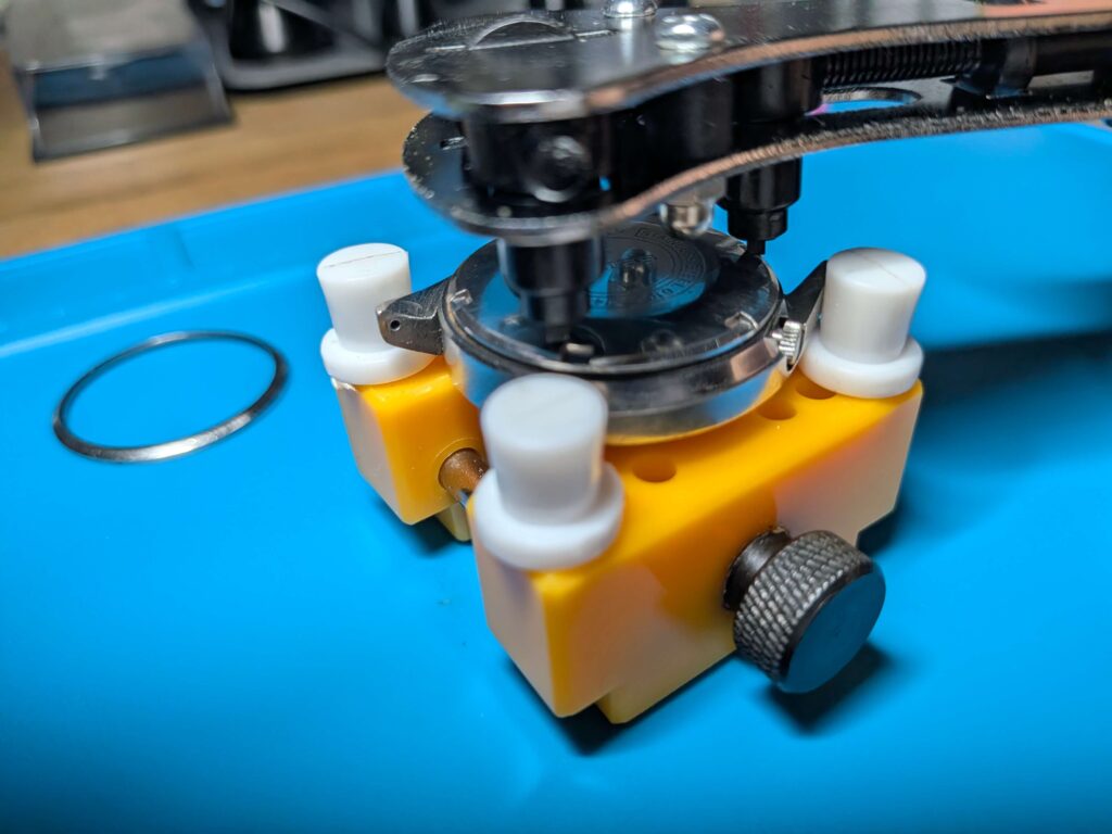 3点式裏蓋オープナーの爪をスクリューバックの溝にしっかりと噛み合わせセイコー5アクタスの裏蓋を回して開けている様子