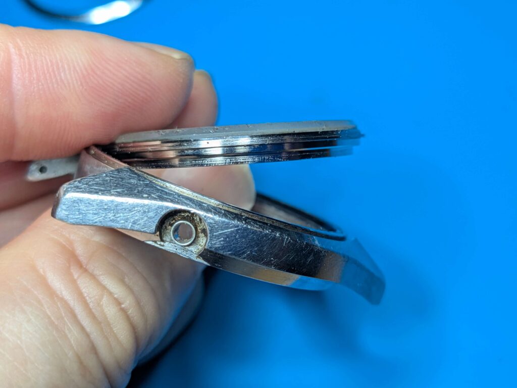 時計ケースの裏側から指でミネラルガラスを強く押し出してセイコー5アクタスの風防を取り外している様子