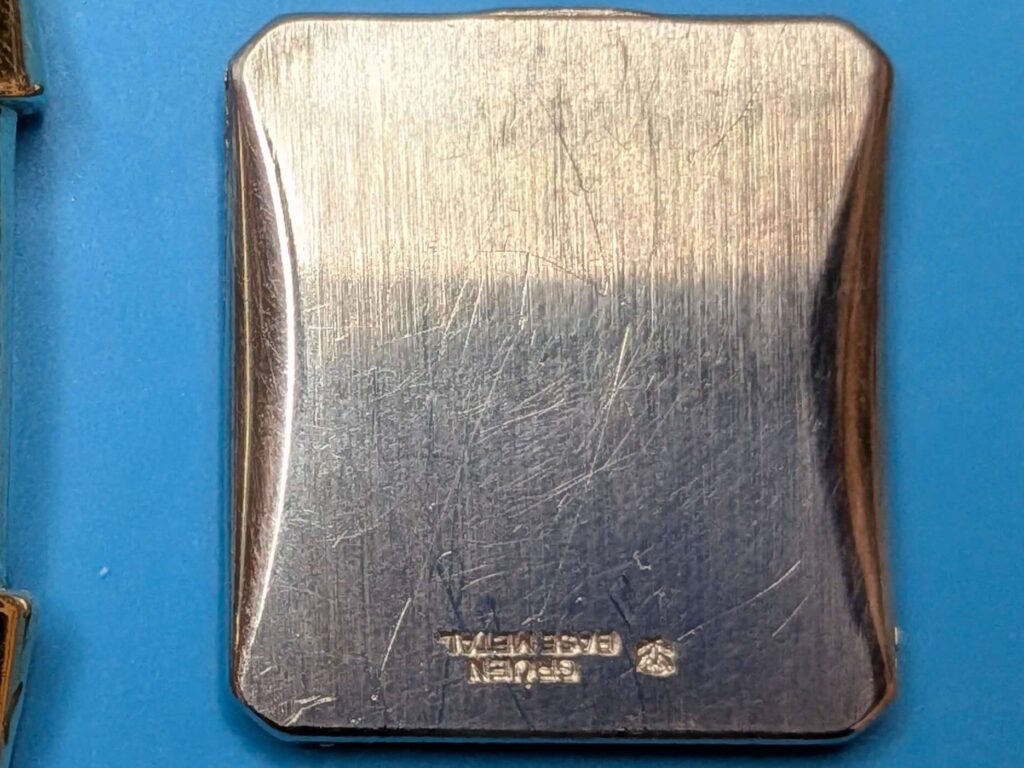 経年変化による小傷と「GRUEN BASE METAL」の刻印が見られるヴィンテージ時計の裏蓋外側のクローズアップ