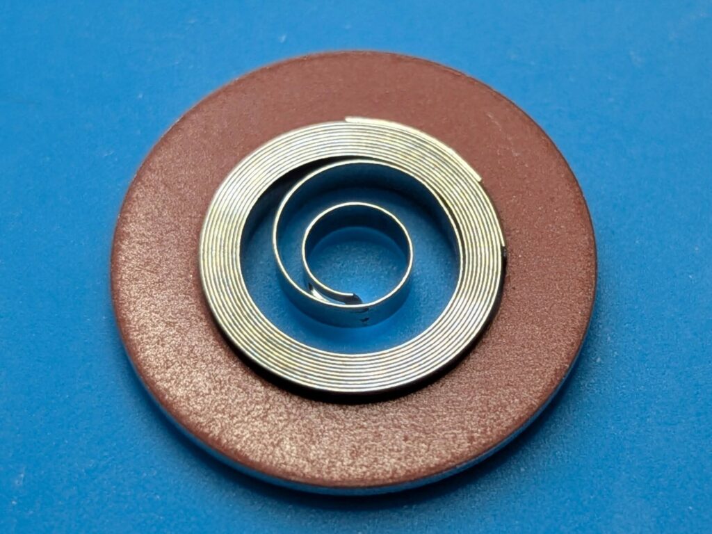 香箱に投入する前の金属リングに巻かれた状態の新品の時計用ゼンマイ