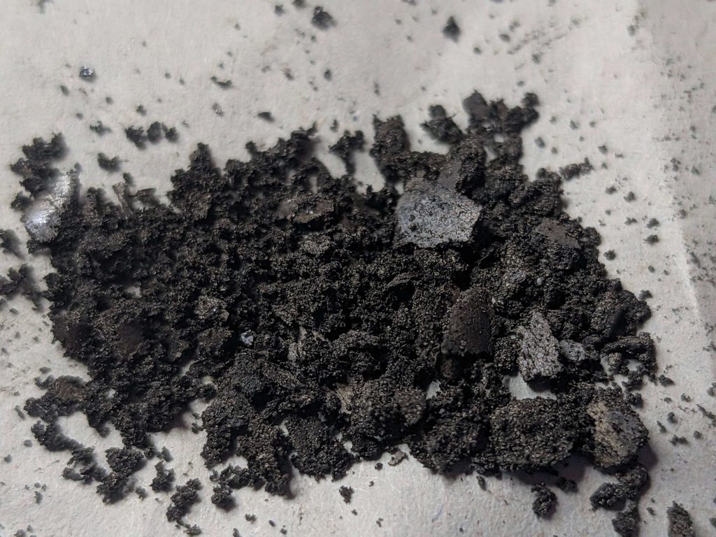 分解したボタン電池SR43SWの内部にある黒い正極活物質(酸化銀)の拡大写真