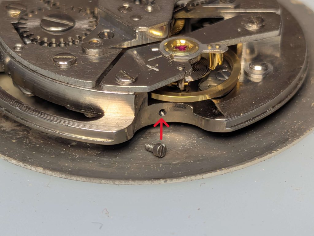 テン輪の横にある機止めネジが本来取り付けられるネジ穴の位置を示した写真
